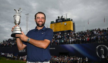 Scottie Scheffler in front of the leaderboard with the Claret Jug