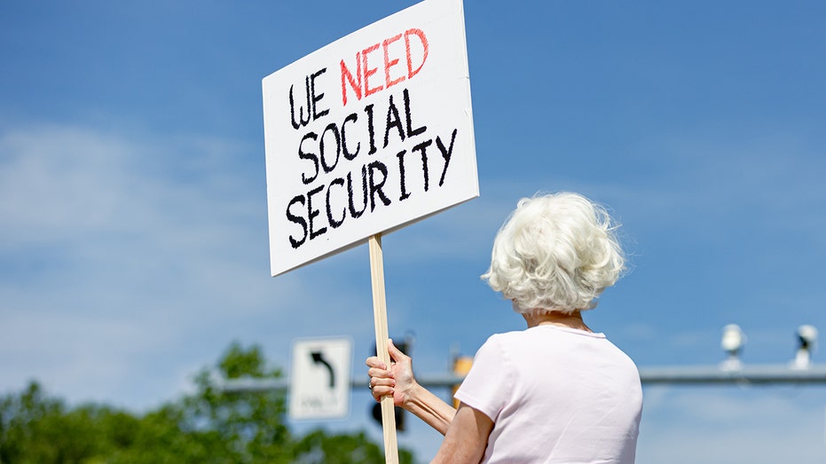 Woman holds sign at Social Security headquarters