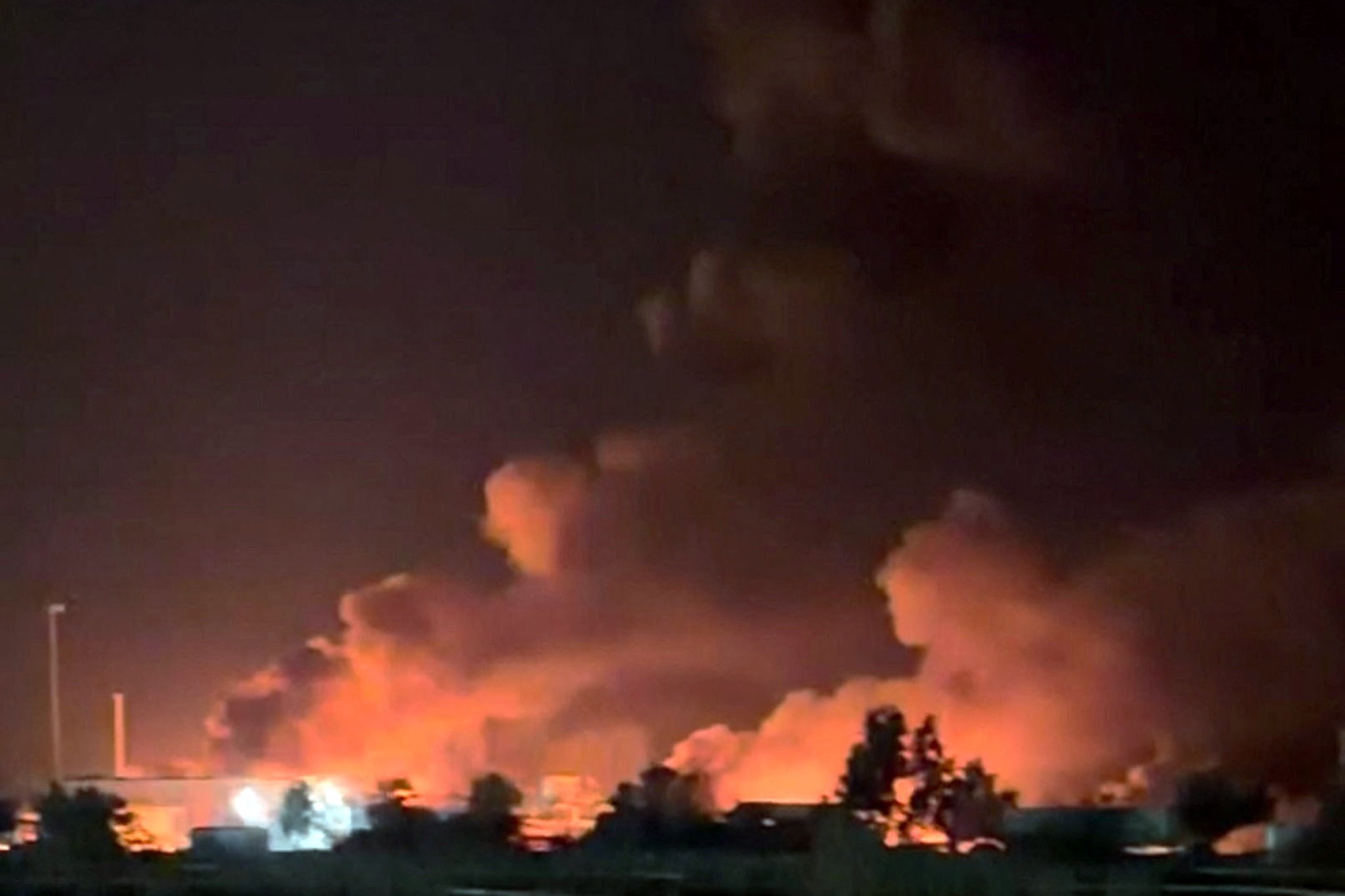 Smoke rises from a port, near Strait of Hormuz, following a US strike in Kuhestak on 8 July