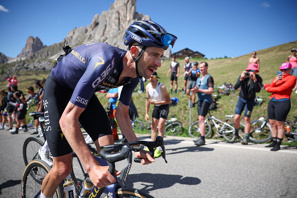 Close up of Harper out of the saddle climbing with spectators in the background
