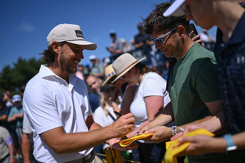 Tommy Fleetwood signs merchandise for supporters at Royal Birkdale