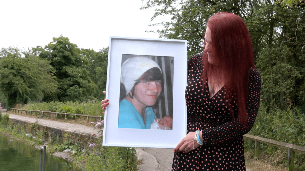 \u200bBeckie Ramsay holding a picture of her son Dylan who died while swimming in open water