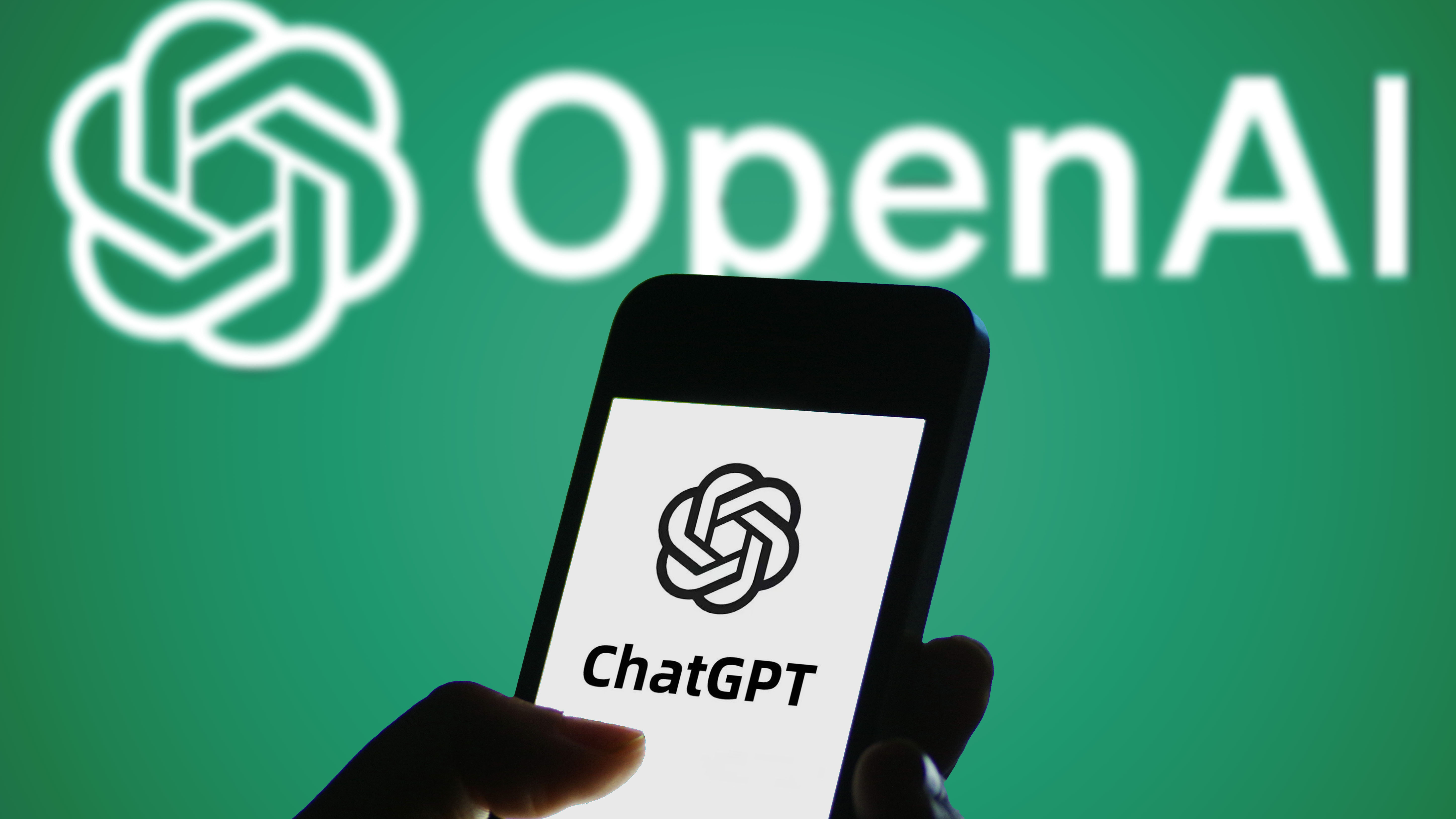 In this photo illustration, the logo of ChatGPT is displayed on a smartphone screen with an OpenAI logo in the background.
