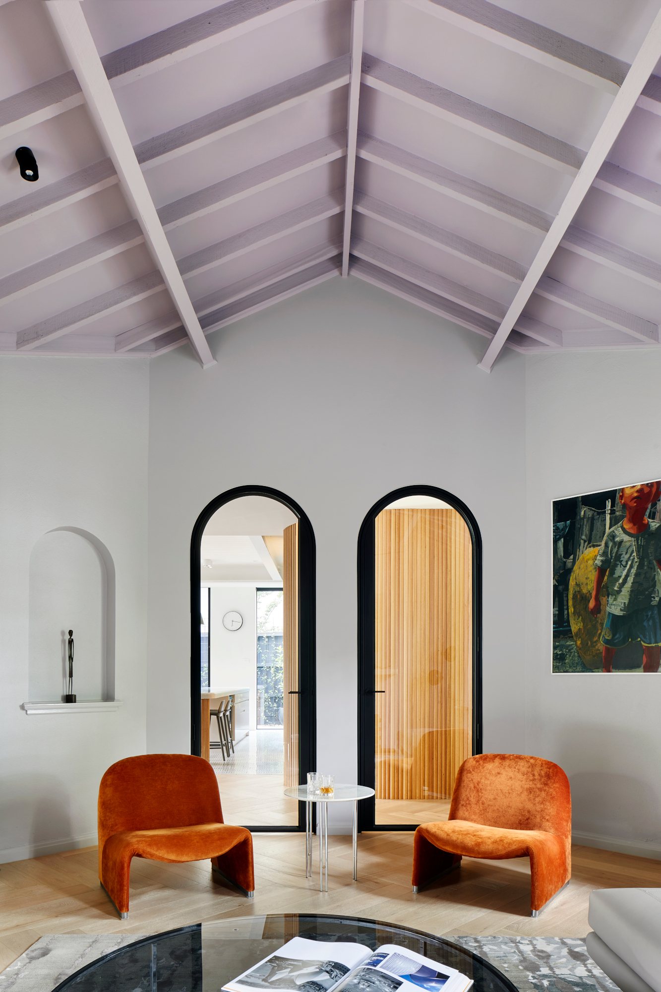 Sitting room with lavender painted vaulted ceiling, white walls and burnt orange armchairs