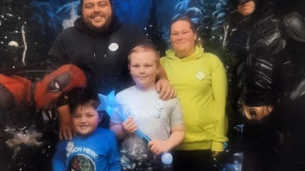 L-R Isaac, 13, Craig, 41, Nathan, 17, and Anna, 37 with people dressed up as superheroes Deadpool and Batman