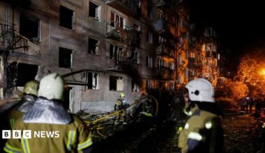 Firefighters work at the site of an apartment building hit by a Russian missile strike in Kyiv