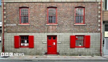 Two images side by side. The right side shows a picture of two semi-detached homes. One is painted light blue with a darker blue window sills. The other is bright yellow with orange markings. The left side shows a large industrial brick building with prominent red painted doors and windows.