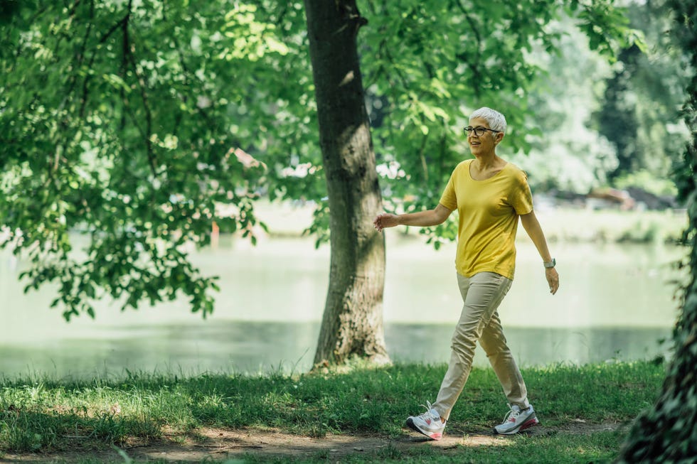 Mature Woman Enjoying Walking Exercise by the Lake mature woman enjoying walking exercise by the lake