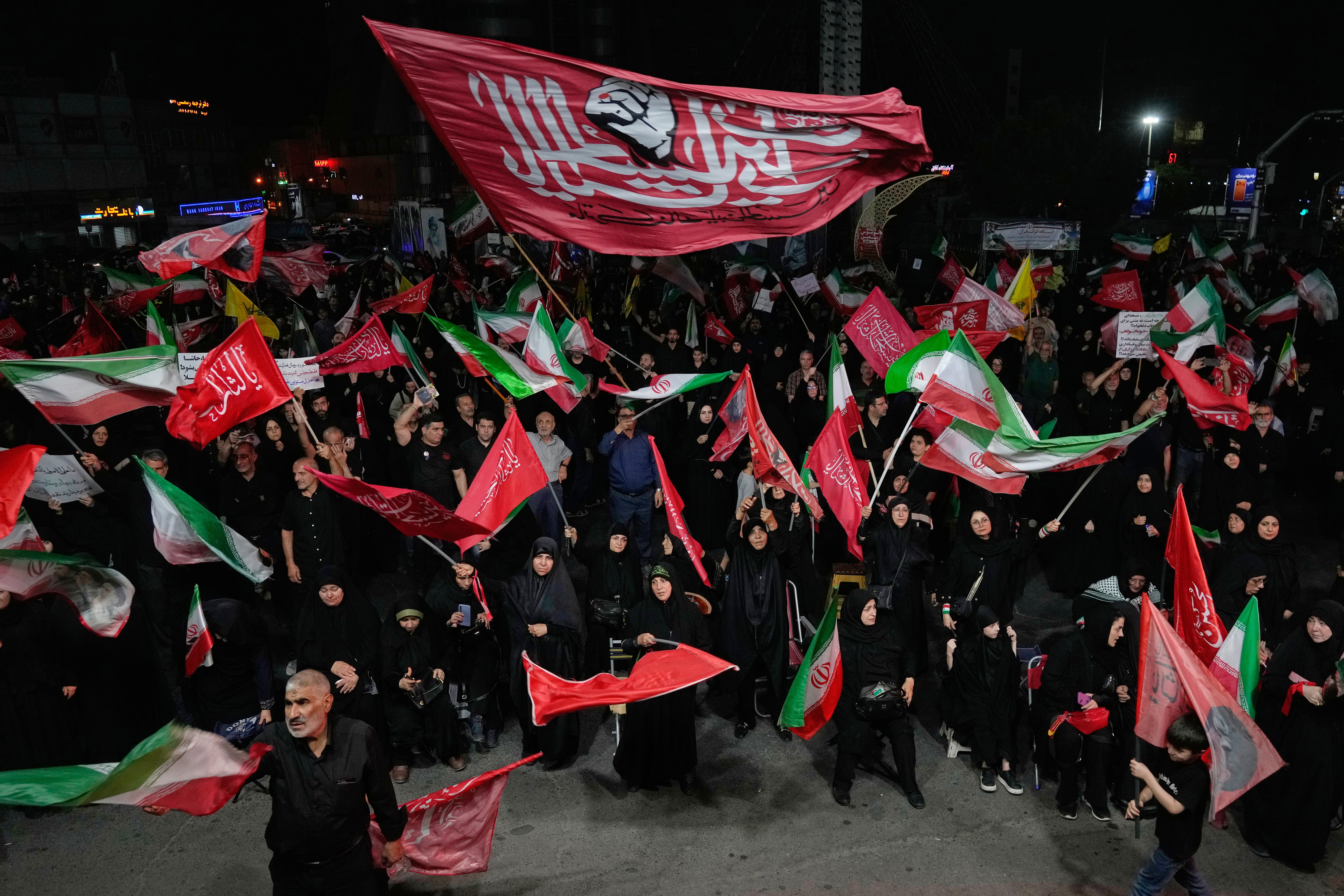 Iranian pro-government demonstrators wave flags in a gathering at a square in Tehran, Iran,