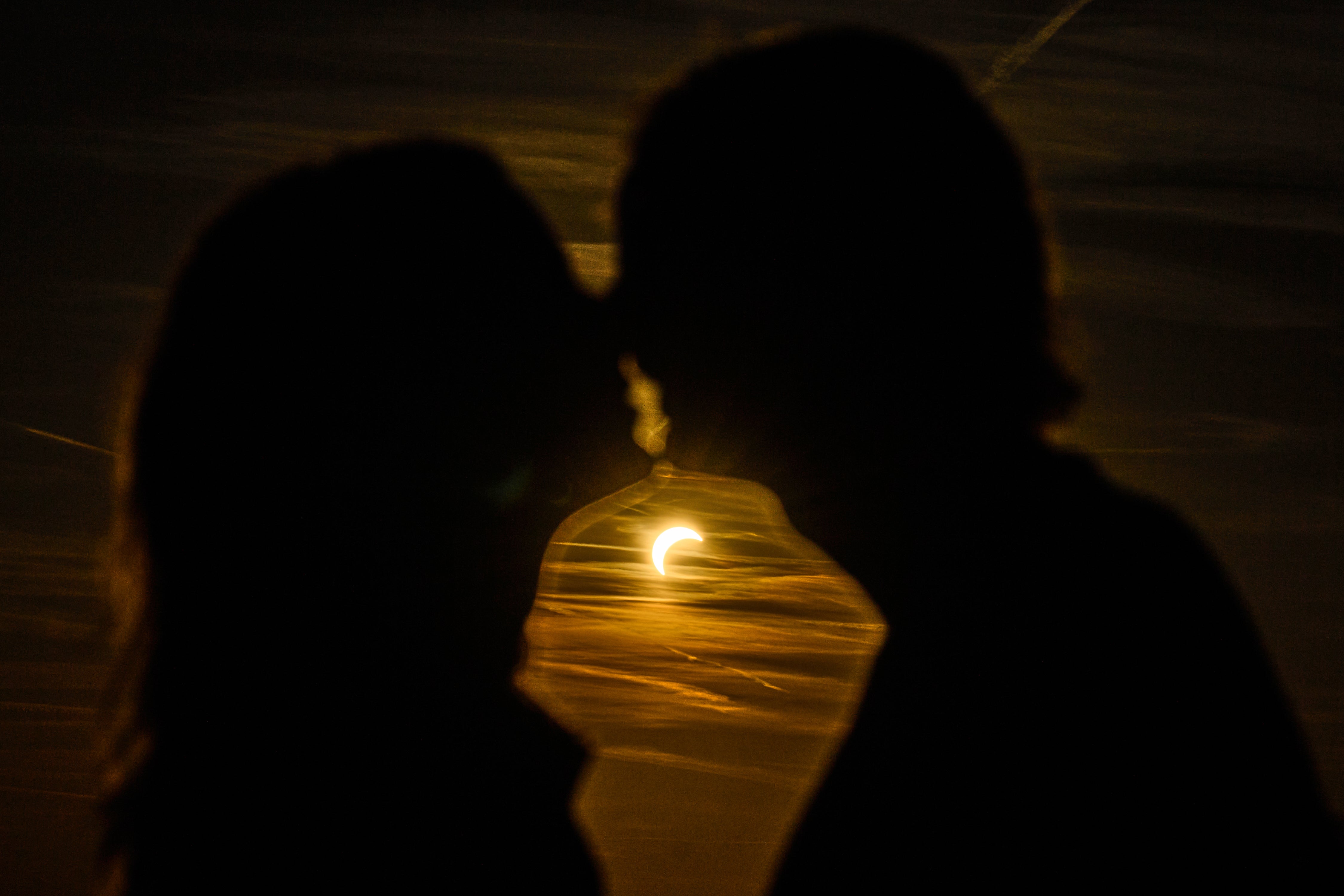 A couple kissees during a partial solar eclipse at the former airport Tempelhof in Berlin, Germany, Wednesday, Aug. 12, 2026.