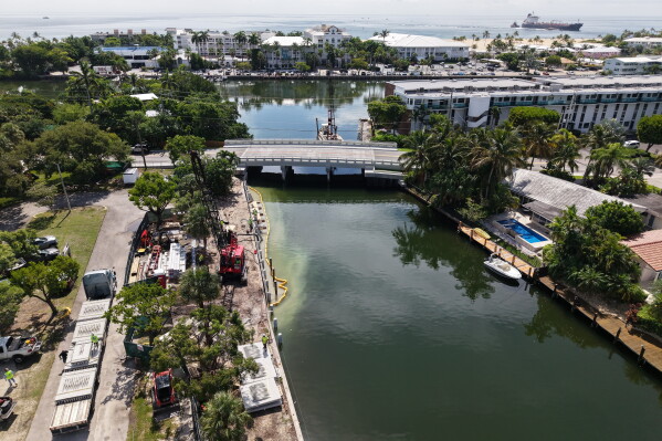 Workers install a 3D-printed living seawall manufactured by Kind Designs at the Church by the Sea, Tuesday, Aug. 4, 2026, in Fort Lauderdale, Fla. (AP Photo/Daniel Kozin)