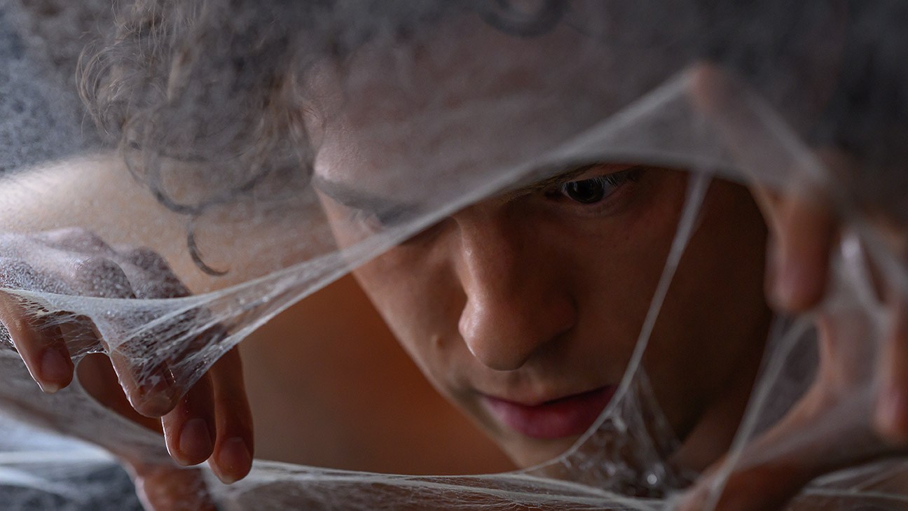 Peter Parker (Tom Holland) peers through the web in Columbia Pictures Spider-Man: Brand New Day