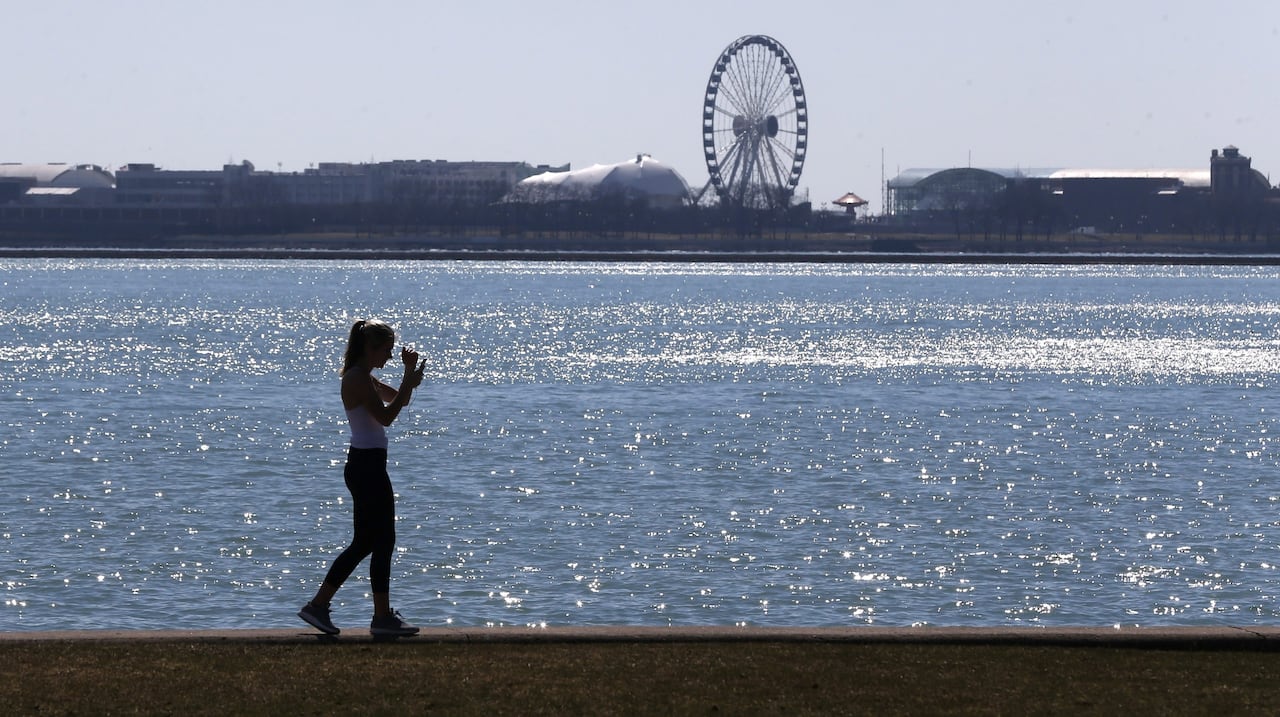 In this March 24, 2017 file photo, a lone woman walks the trail along Lake Michigan at Chicago' North Avenue beach.