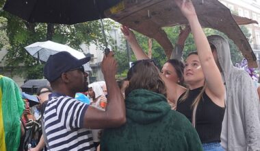 Revellers held up umbrellas and cardboard to shield themselves from the rain on family day at the Notting Hill Carnival