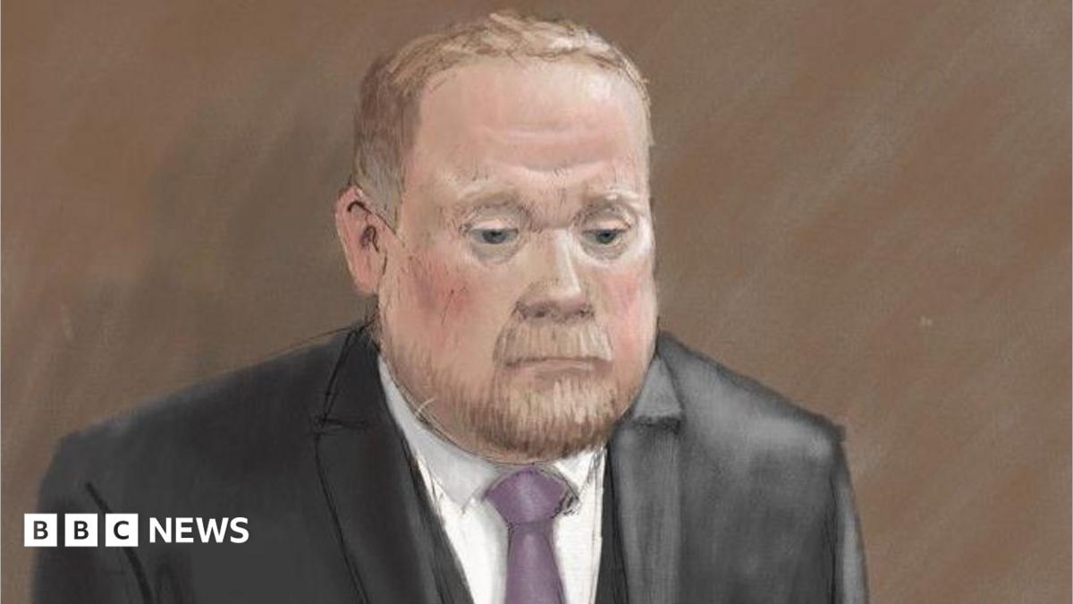 Courtroom sketch of Robert Bush in a dark three-piece suit standing alone against a plain brown background. He wears a light-coloured shirt and a purple tie. The illustration is rendered in soft pencil and pastel tones.