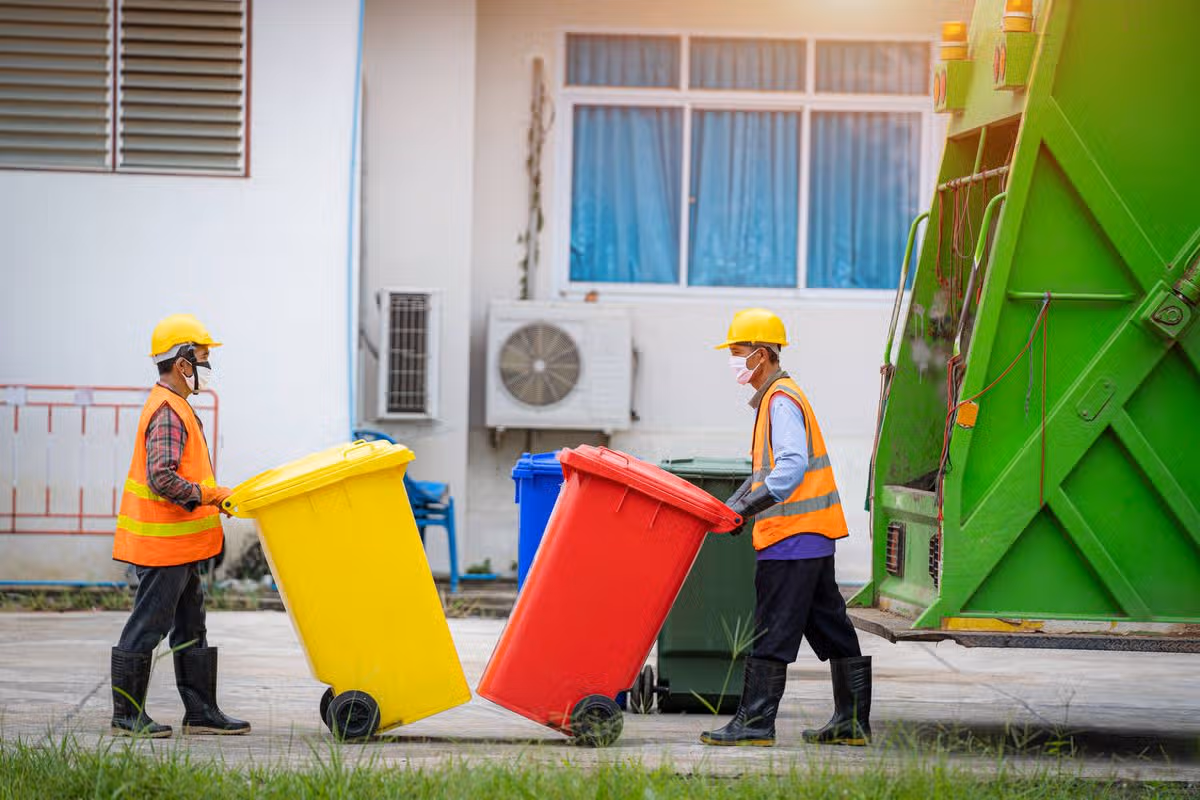 Two men in uniform collecting garbage at city,Trash and rubbish collection.