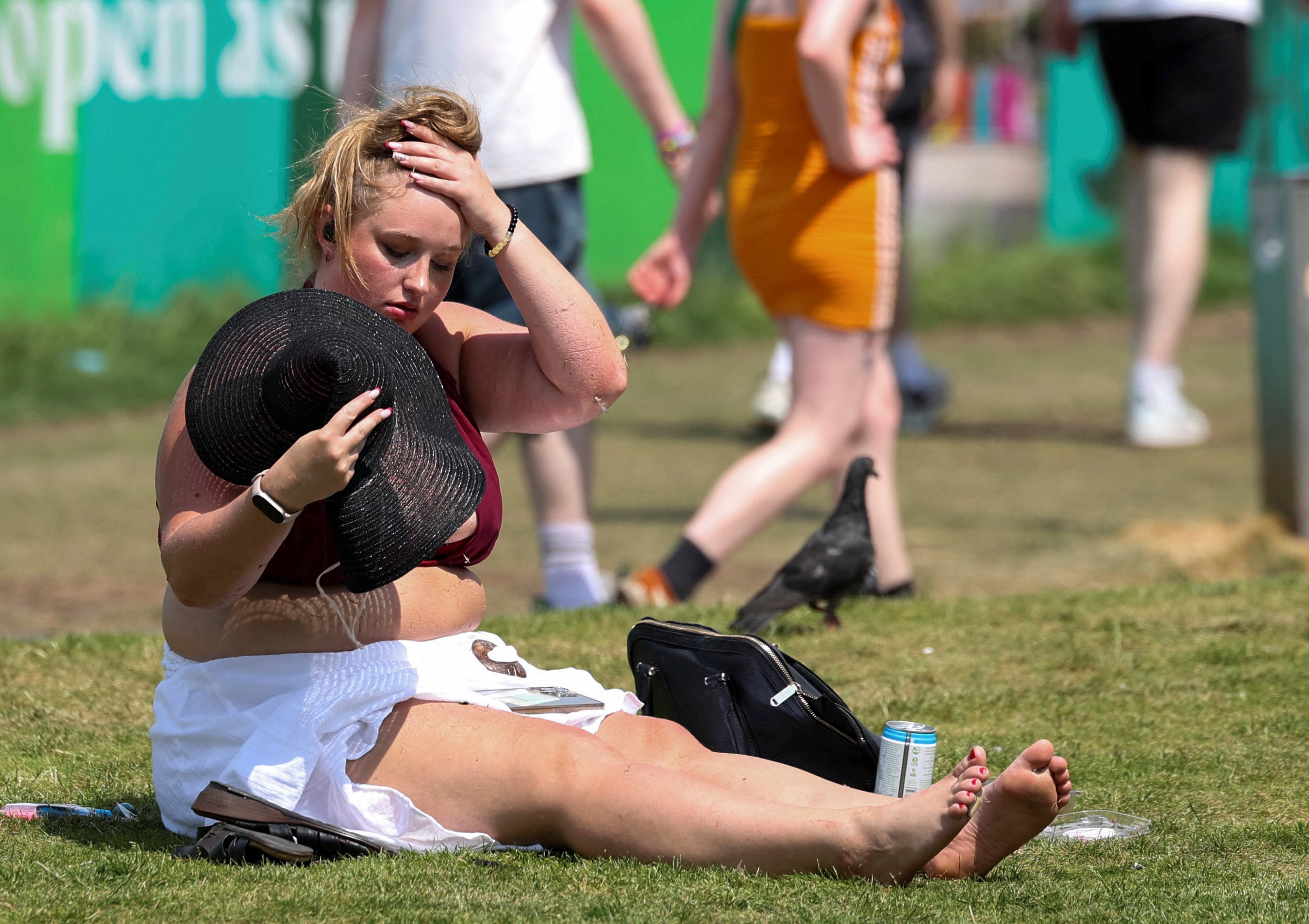 A woman attempts to cool herself down as temperatures reach record levels