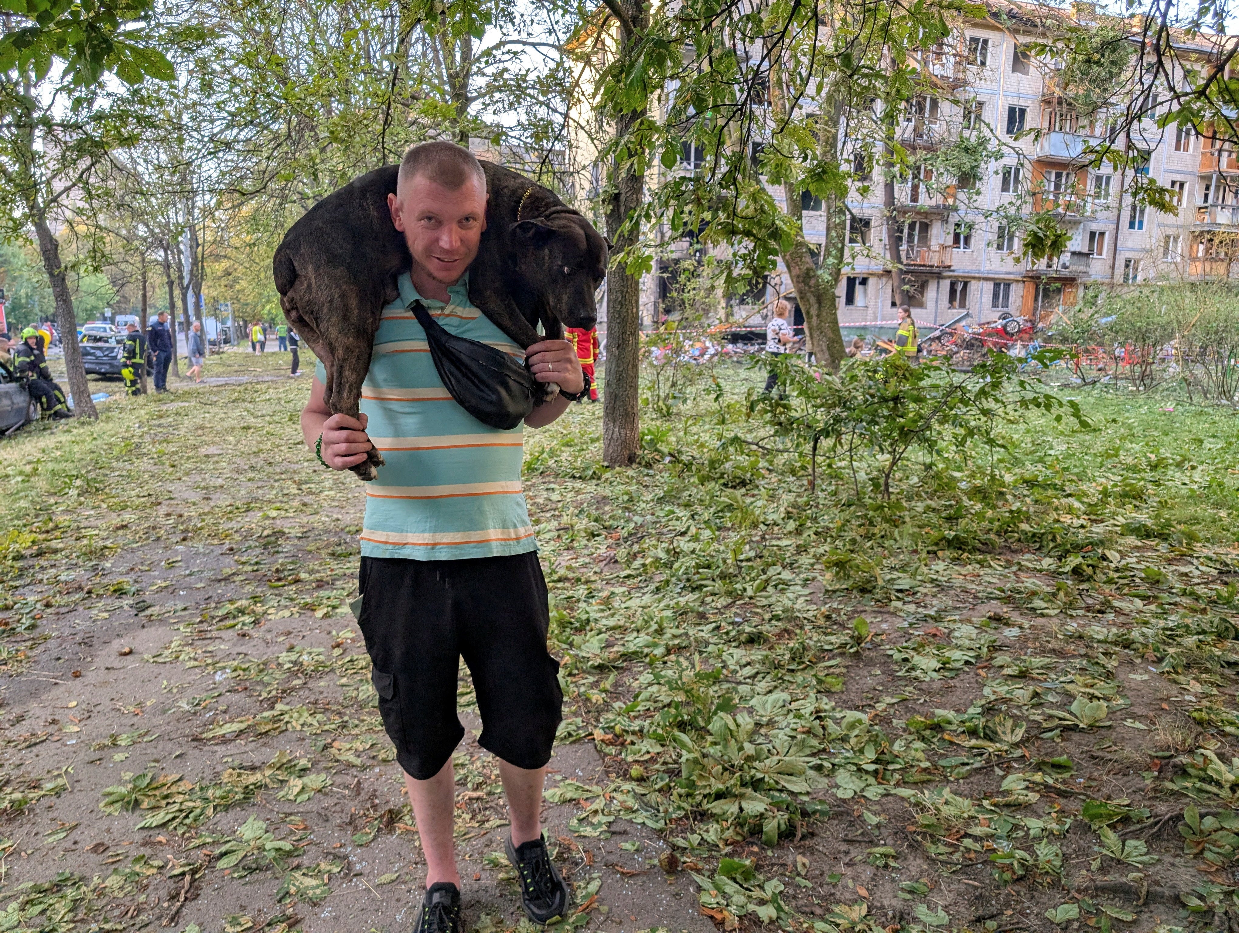 A man carries his dog at the site of an apartment building hit by a Russian missile strike, amid Russia's attack on Ukraine, in Kyiv, Ukraine
