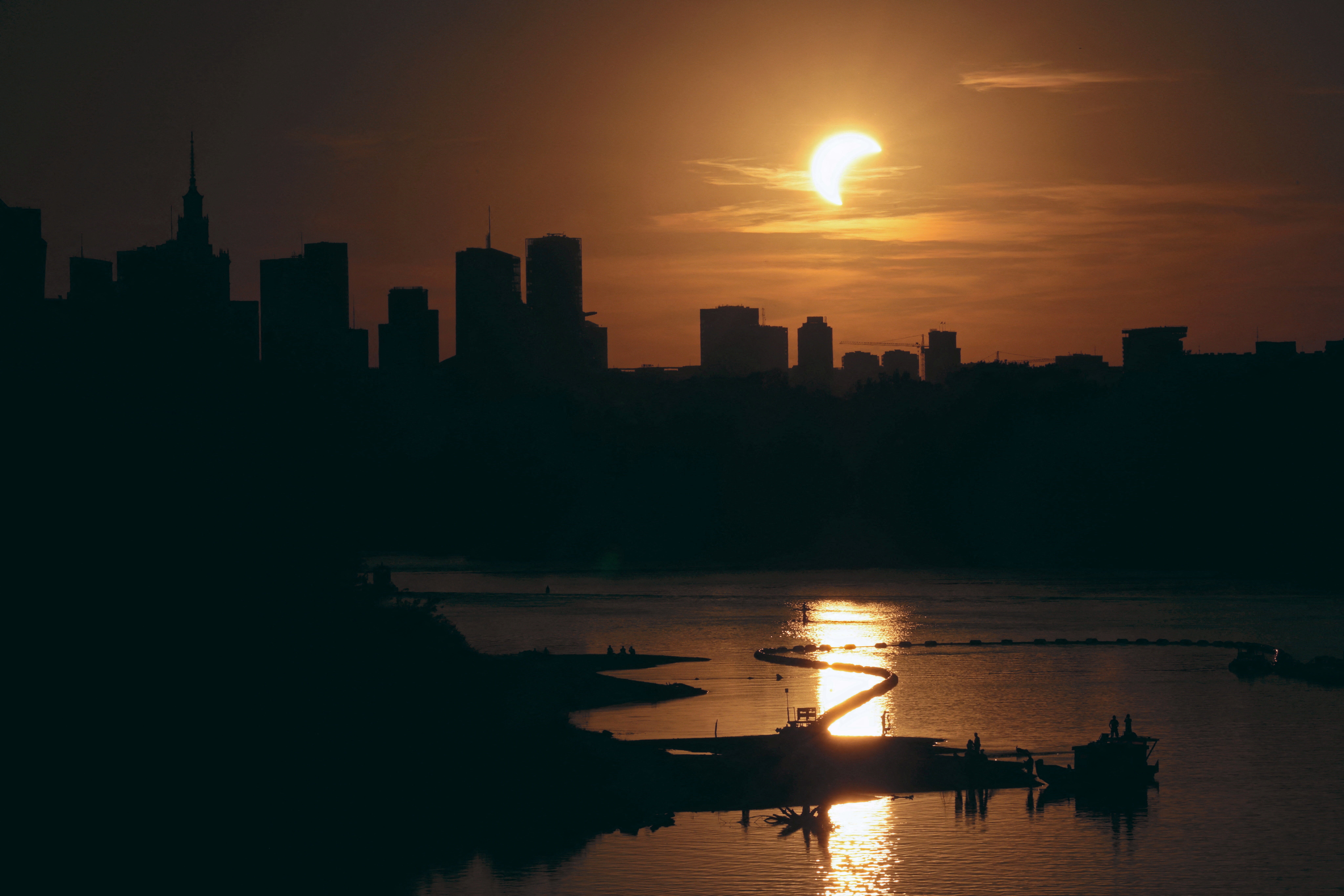 The sun over the skyline during a partial solar eclipse in Warsaw, Poland, August 12, 2026