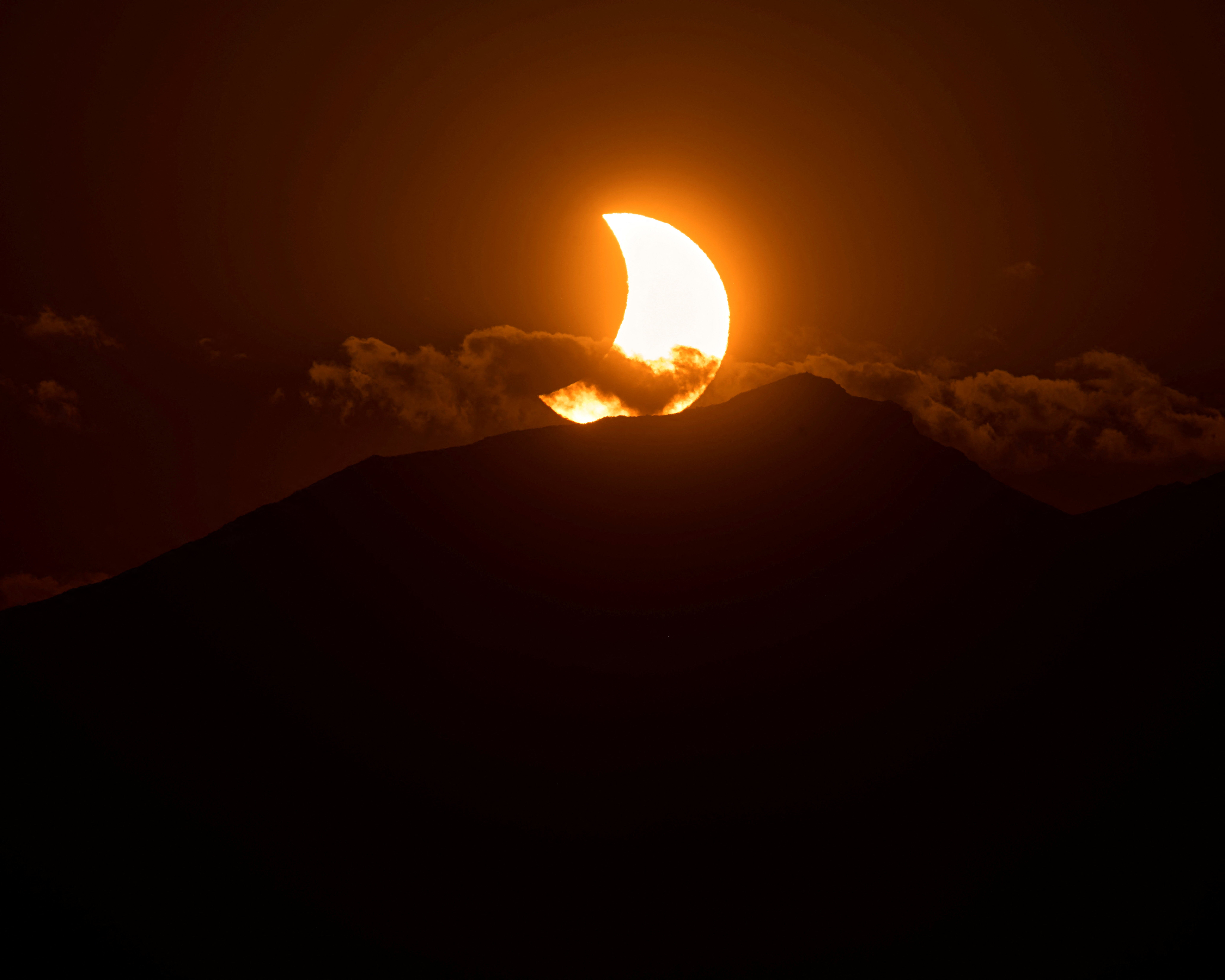 The moon partially covers the sun during a solar eclipse over mountains near the northern Spanish town of Reinosa, August 12, 2026
