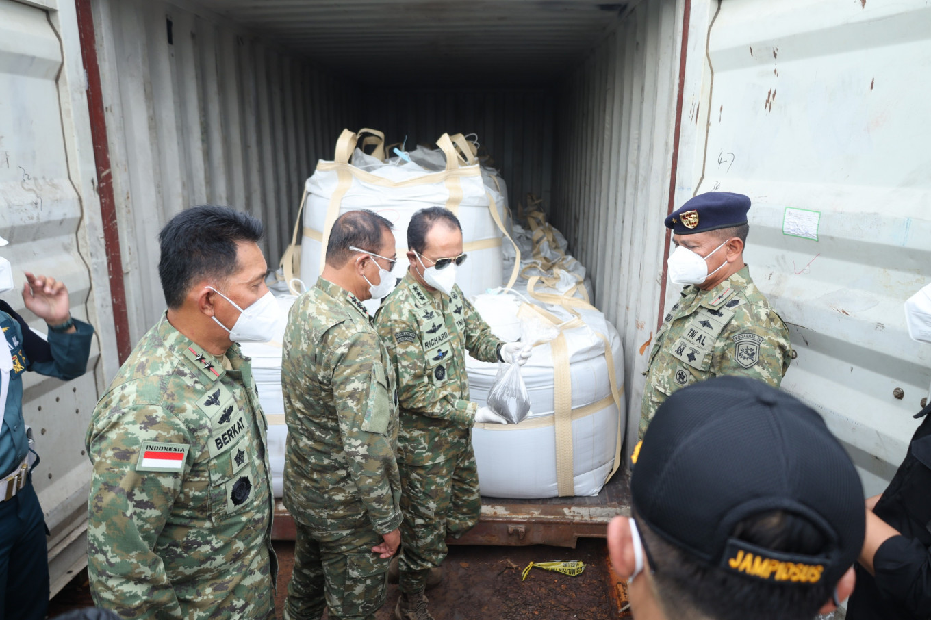 Indonesian Military (TNI) chief of general staff Lt. Gen. Richard Taruli H. Tampubolon (second right) holds a sack of mineral black sand while the Republic of Indonesia Fleet Command (Koarmada RI) Vice Adm. Denih Hendrata (second left) looks on at the Indonesian Navy&rsquo;s Naval Command (Kodaeral) IV/Batam headquarters&rsquo; pier in Batam, Riau Islands, on May 26, 2026. The Indonesian Navy intercepted on May 17, 2026, a tugboat and a barge carrying 25 containers of some 390 tonnes of raw minerals containing illegal rare earth metals and radioactive elements in Riau Islands waters.