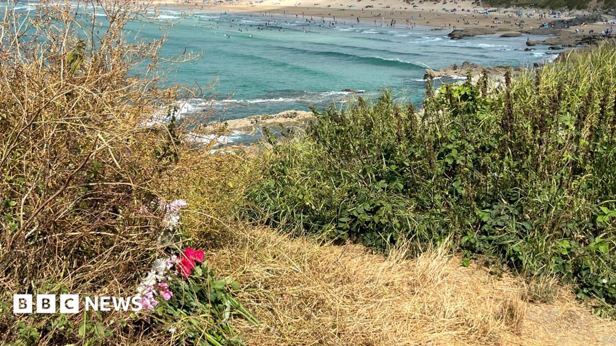Flowers left on a cliff overlooking a beach