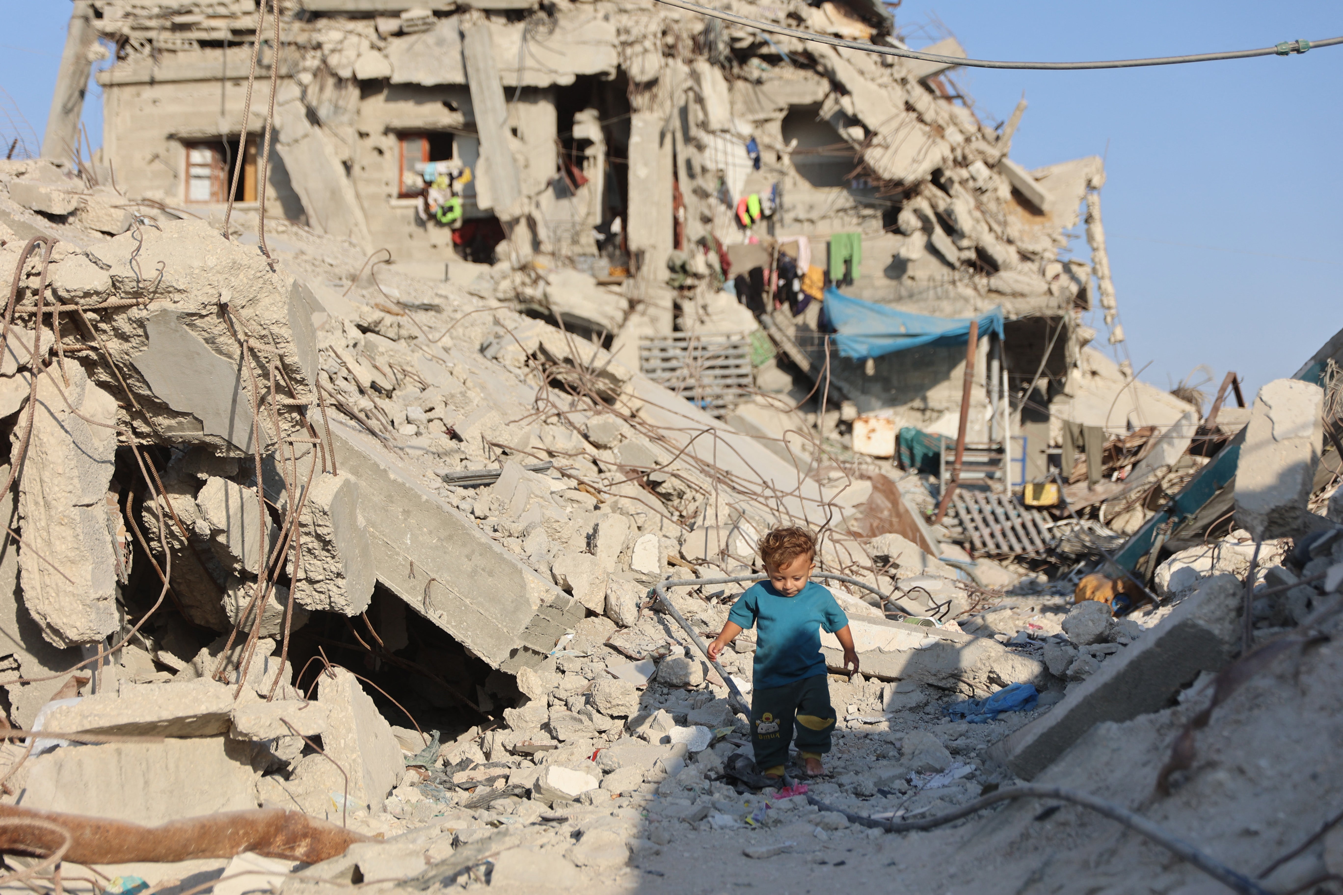 A Palestinian child walks past the rubble of destroyed buildings in the Jabalia camp for Palestinian refugees in the northern Gaza Strip