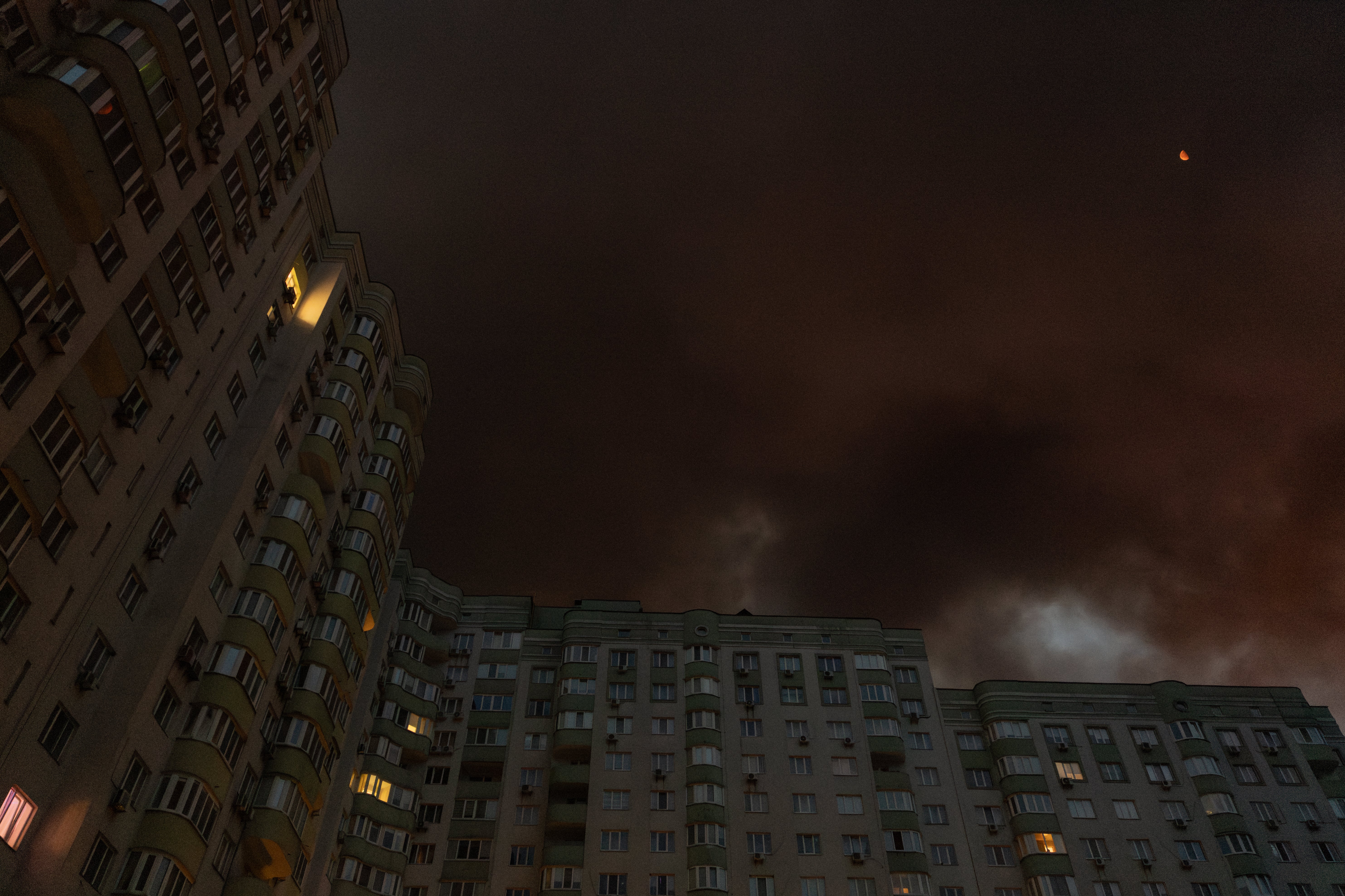 Smoke rising from a warehouse destroyed during massive Russian ballistic missile and drone strikes next to a residential building on the outskirts of Kyiv