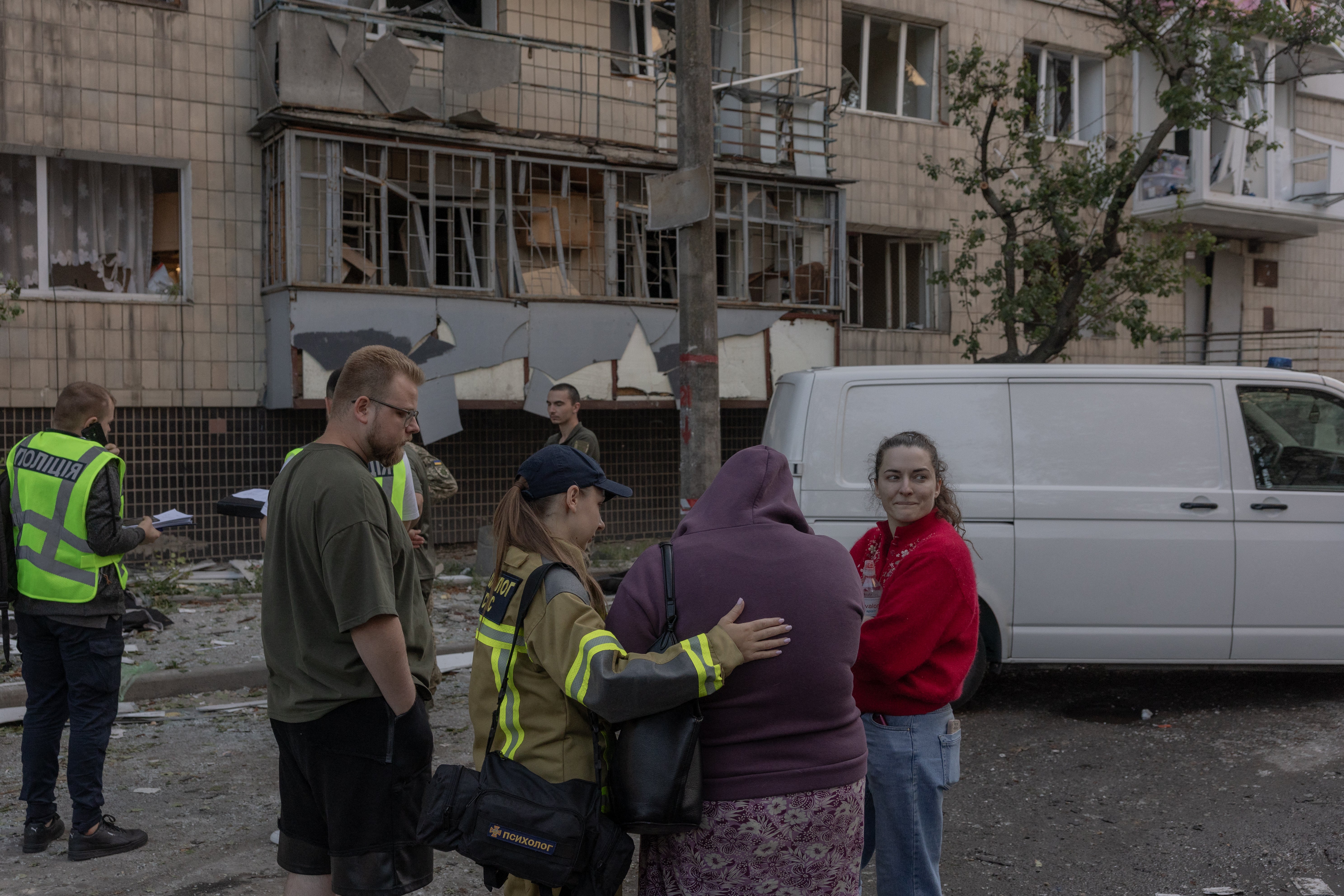 Emergency services console the relative of a victim hit by Russian strikes