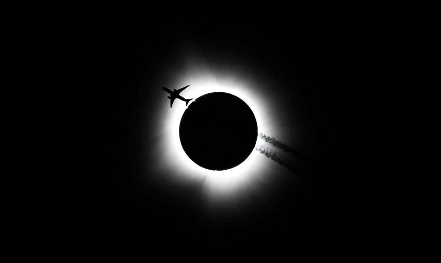 An airplane passes by as the total solar eclipse is seen from Bloomington, Indiana, on Monday, April 8.