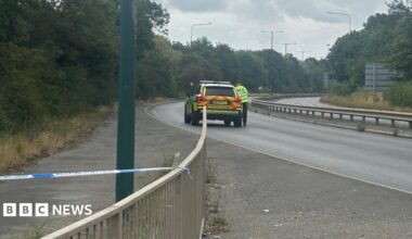 The closed section of the A66. A police car is parked on the silent, empty, dual-carriageway.