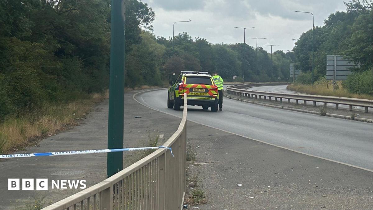 The closed section of the A66. A police car is parked on the silent, empty, dual-carriageway.