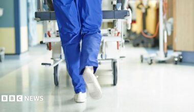 Surgeon walking a hospital bed down a corridor