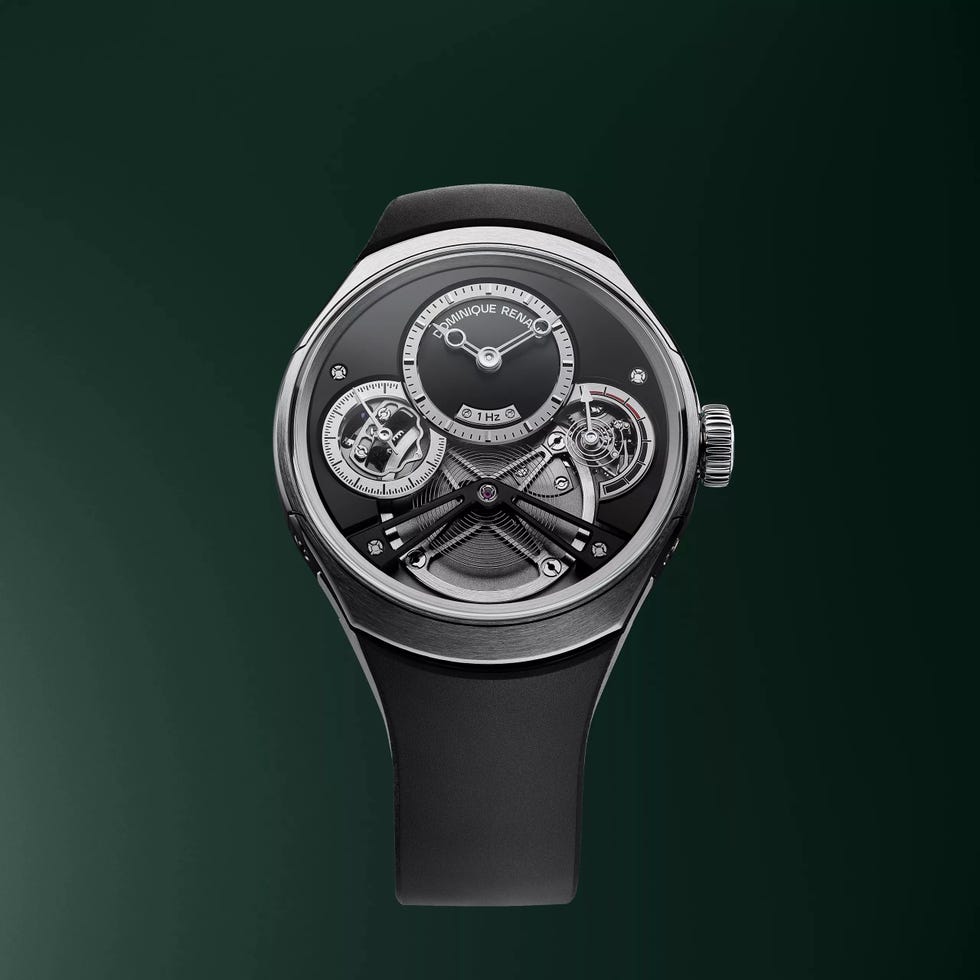 Luxury mechanical watch with open workings and a black strap against a dark green background. Luxury mechanical watch with open workings and a black strap against a dark green background.