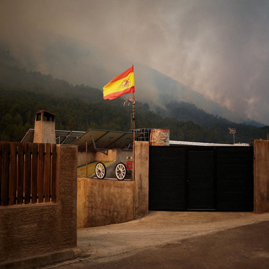 A Spanish flag at a house near a wildfire in Onda.