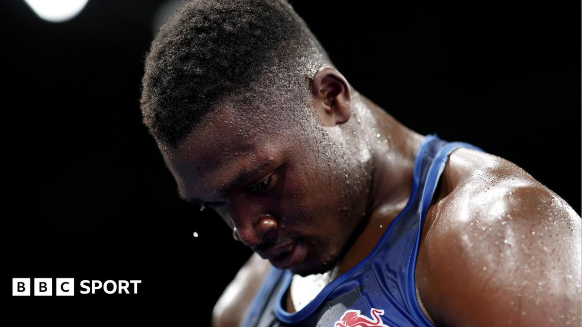 Dimeji Shittu, wearing a blue vest, looks down