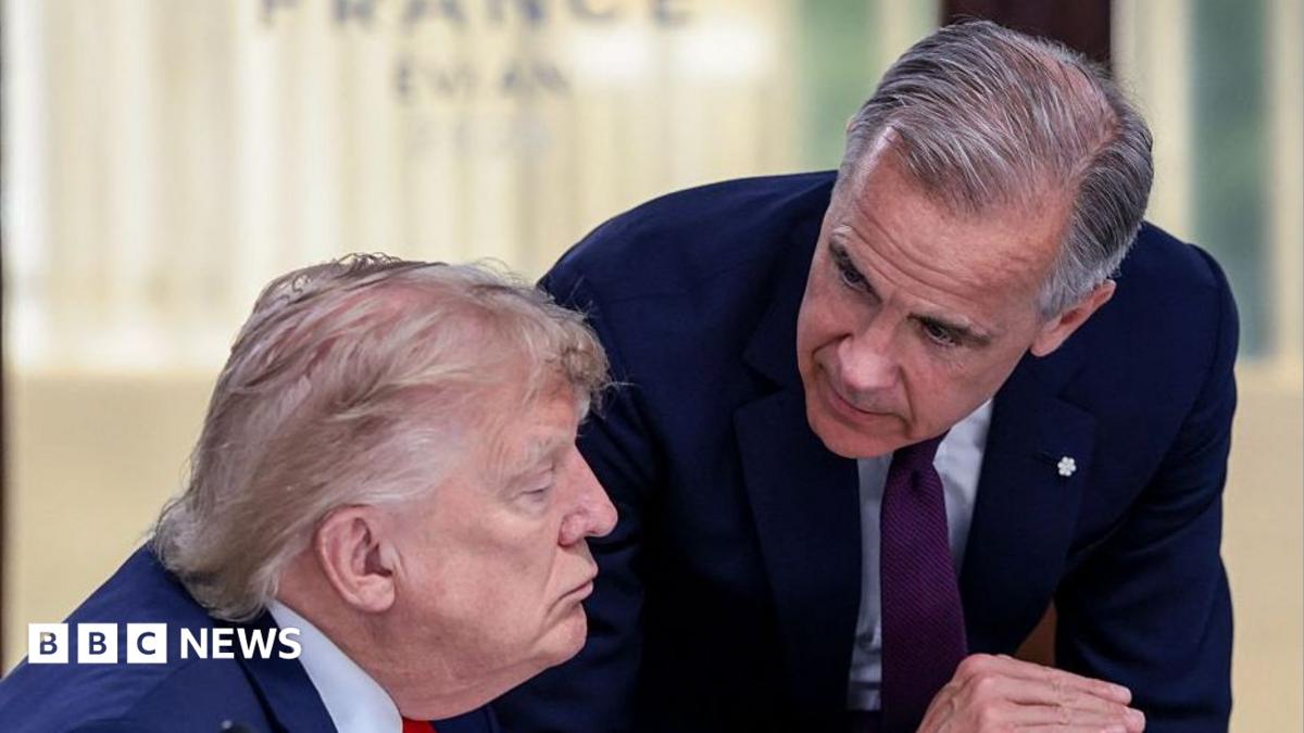 US President Donald Trump (left) speaks with Canada's Prime Minister Mark Carney during a work lunch as part of the G7 summit, in Evian, eastern France, on June 16, 2026. Trump is sitting down while Carney is standing over but leaning into the conversation.