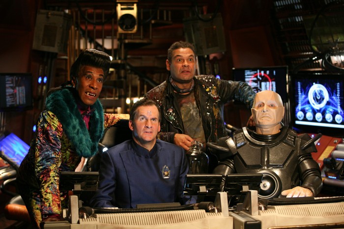 Danny John-Jules as the Cat, Chris Barrie as Arnold Rimmer, Craig Charles as Dave Lister, and Robert Llewellyn as Kryten in Red Dwarf Danny John-Jules as the Cat, Chris Barrie as Arnold Rimmer, Craig Charles as Dave Lister, and Robert Llewellyn as Kryten in Red Dwarf