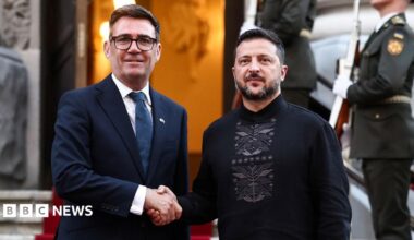 Burnham and Zelensky pose looking at the camera while shaking hands with soldiers behind them, on the steps of Horodetskyi House in Kyiv on Monday.