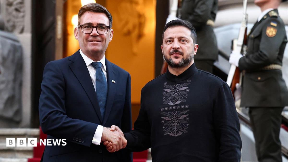 Burnham and Zelensky pose looking at the camera while shaking hands with soldiers behind them, on the steps of Horodetskyi House in Kyiv on Monday.