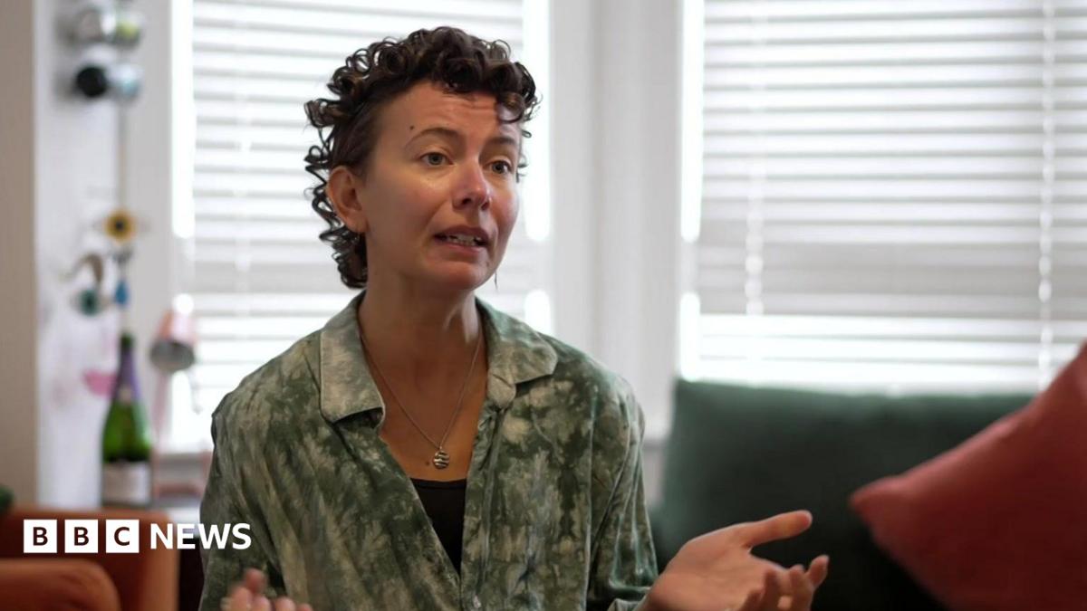 Woman with short brown curly hair wearing a green shirt.
