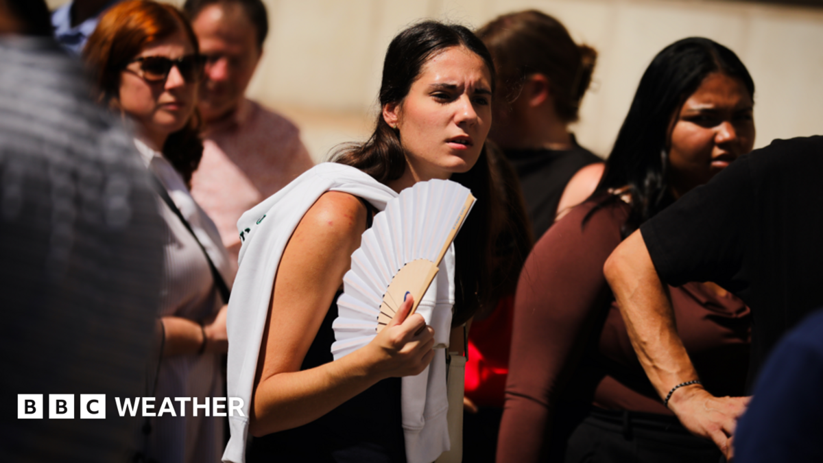 A young woman fans herself in the sunshine on a hot day