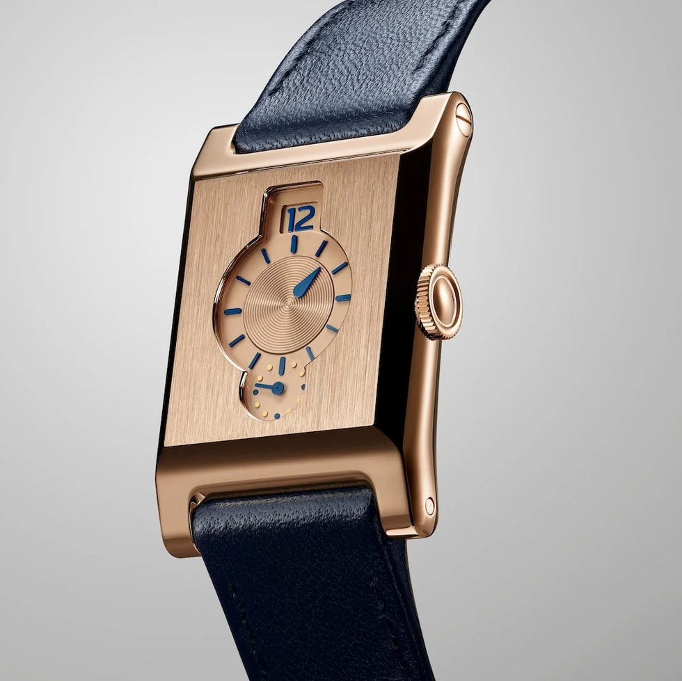 Luxury rectangular gold watch with blue accents and a leather strap against a light background. Luxury rectangular gold watch with blue accents and a leather strap against a light background.