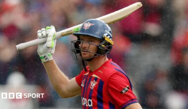 Jos Buttler wearing a helmet and raising his bat while playing for Manchester Super Giants