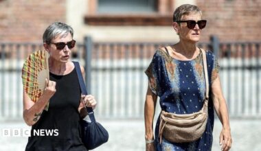 People drink water and use hand fans to protect themselves from the sun in Naples, southern Italy. Photo: 1 August 2026