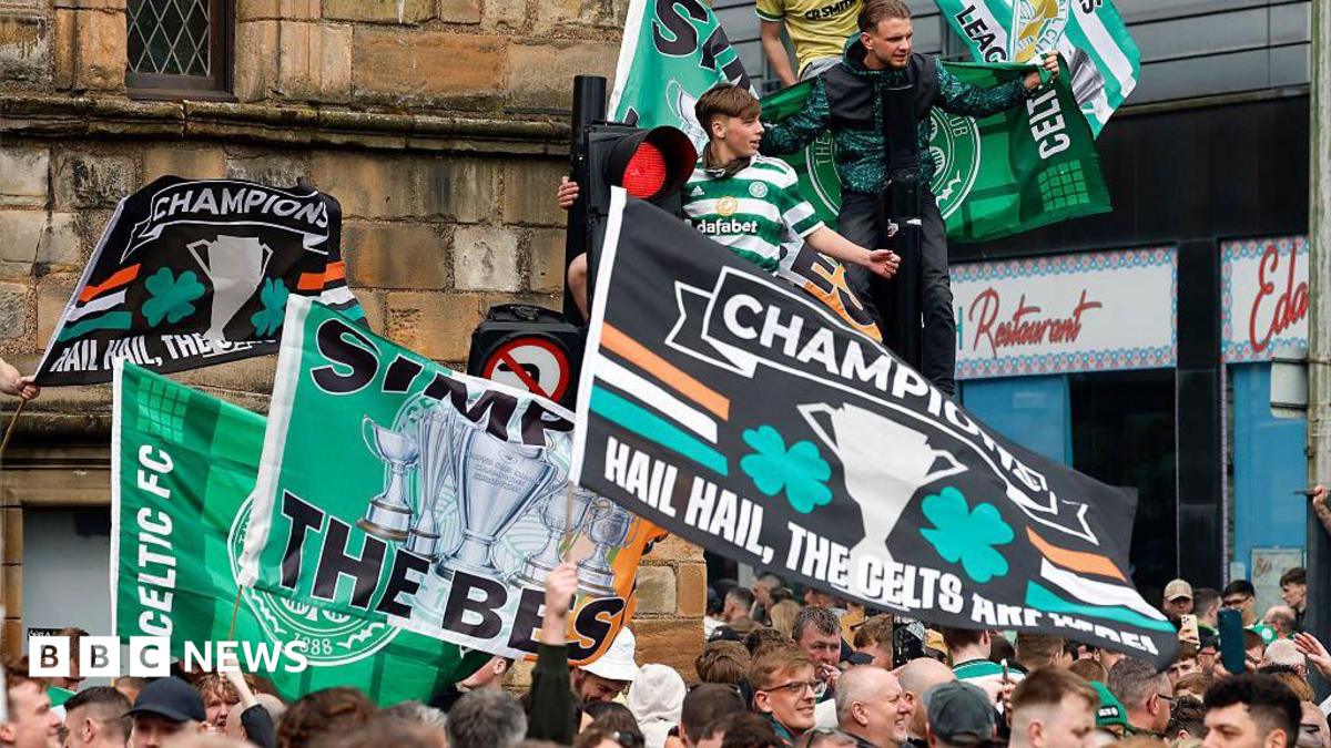 hundreds of celtic flans waving banners in a city centre street
