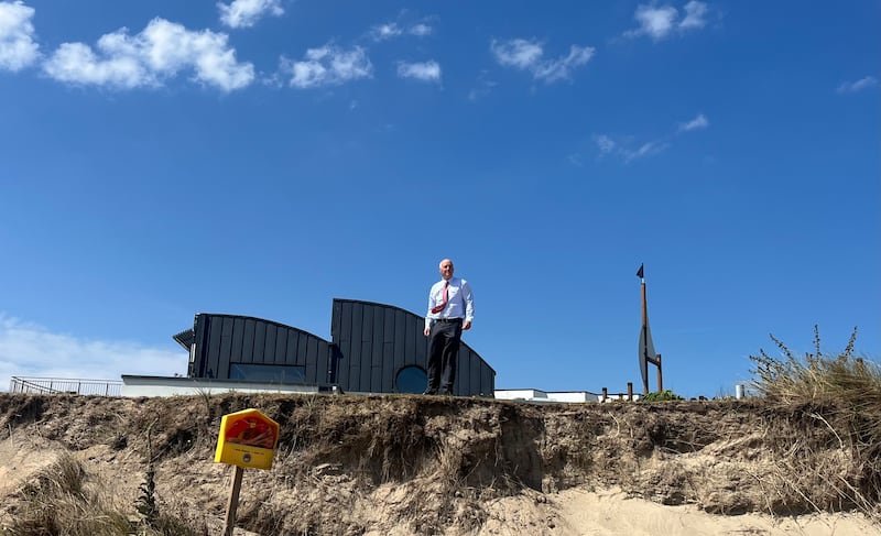 Billy Kell on the heavily eroded bank separating Kelly's Hotel from the beach at Rosslare Strand. Photograph: Steven Carroll