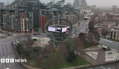 Current advertising structure shows screen in orb on roundabout with cars, bus and lorry