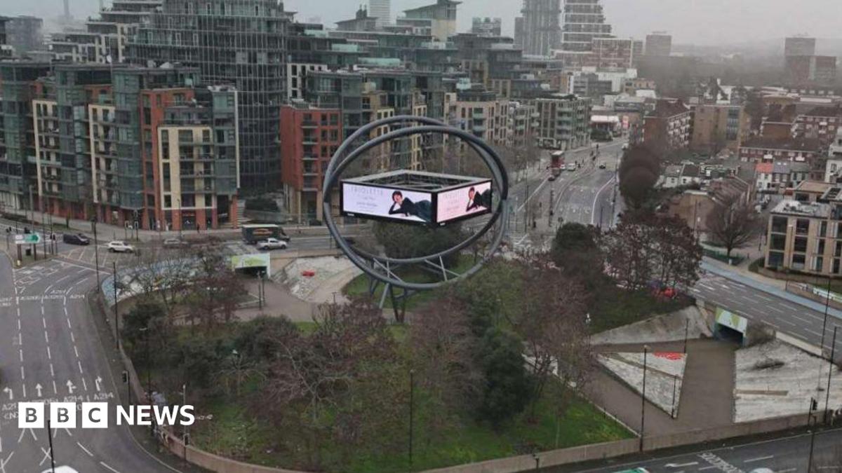 Current advertising structure shows screen in orb on roundabout with cars, bus and lorry