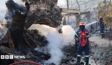 Firefighters work on a wildfire which prompted evacuations on the island of Salamina